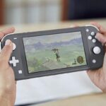 A person playing The Legend of Zelda: Breath of the Wild on a Nintendo Switch Lite.